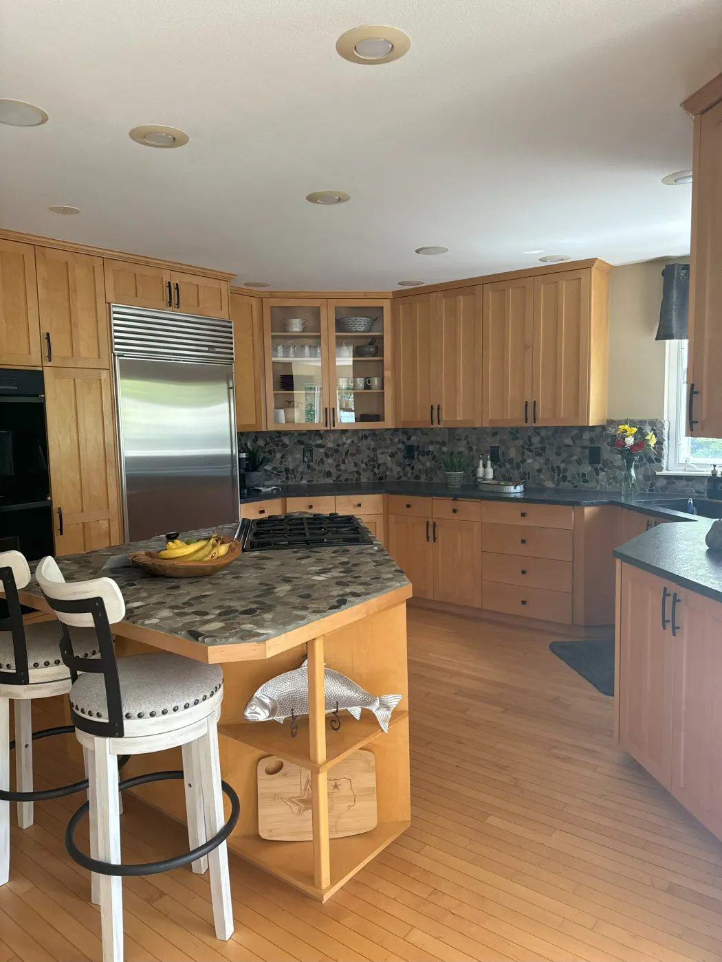 Kitchen with wood cabinetry, granite countertops, stainless steel appliances and a wood island
